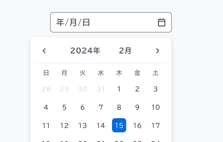 カレンダーの振る舞いを示す図。上部に「年/月/日」というプレースホルダーテキストとカレンダーアイコンが表示された入力フィールドがあり、その下に「2024年 2月」というヘッダーと日付が並んだカレンダーが展開されています。15日が青い背景で強調表示されています。